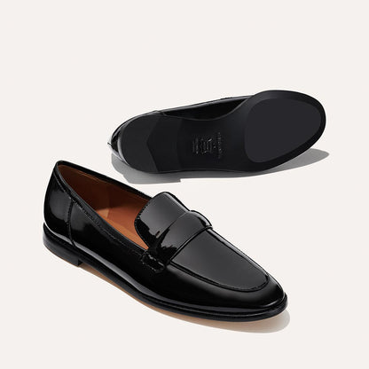 The Andie Loafer in shiny Black Patent, featuring a sleek structured design made from smooth Italian nappa leather with a minimalistic padded keeper detail.