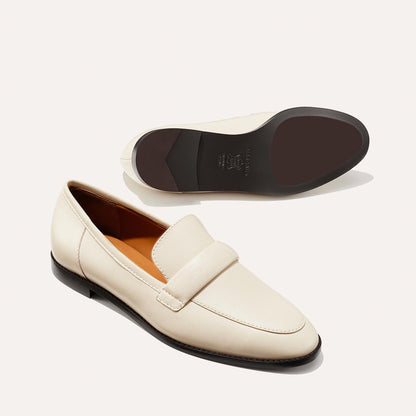 The Andie Loafer in Ecru Nappa, featuring a sleek structured design made from smooth Italian nappa leather with a minimalistic padded keeper detail.