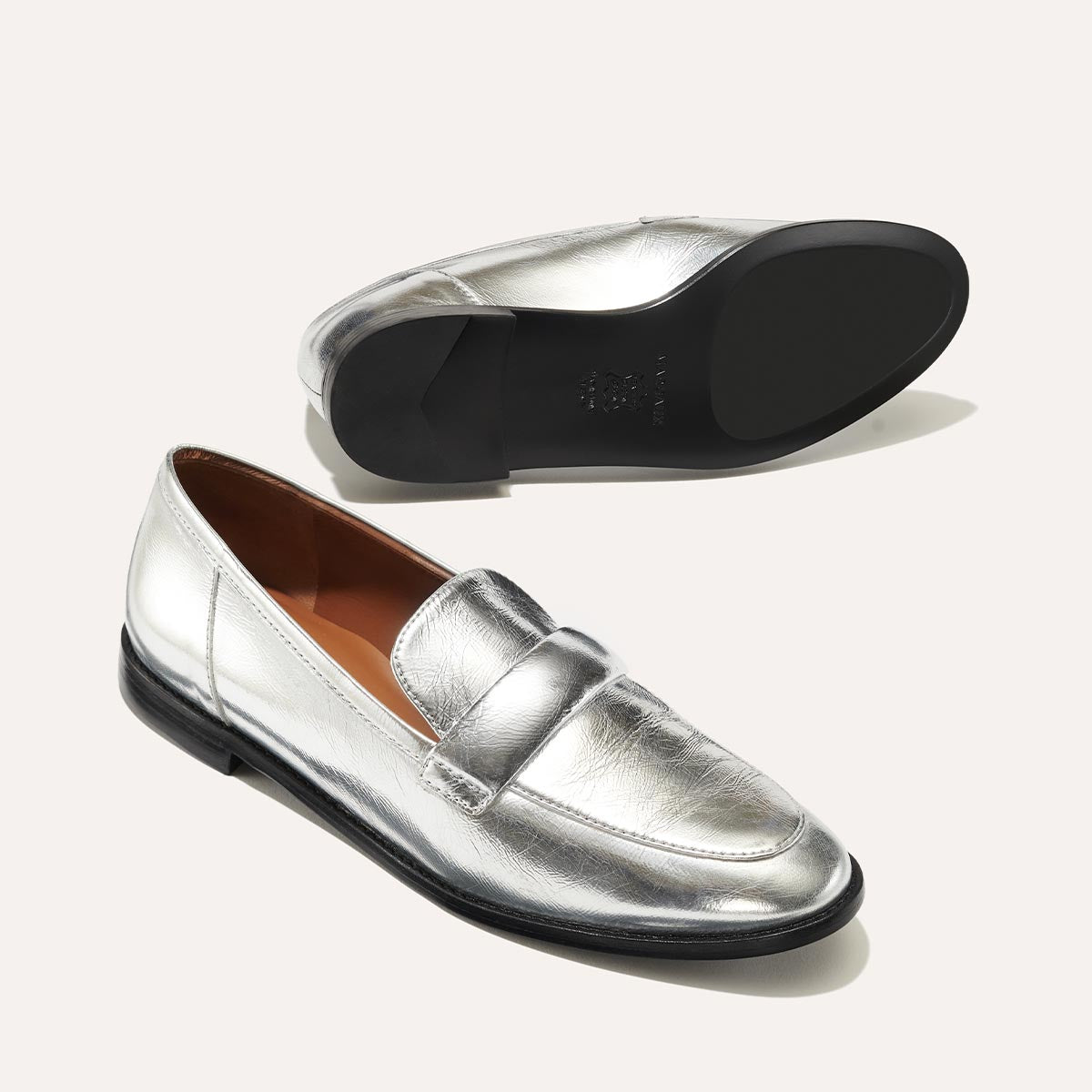 The Andie Loafer in shiny Silver Crinkle Mirror, featuring a sleek structured design made from smooth Italian nappa leather with a minimalistic padded keeper detail.