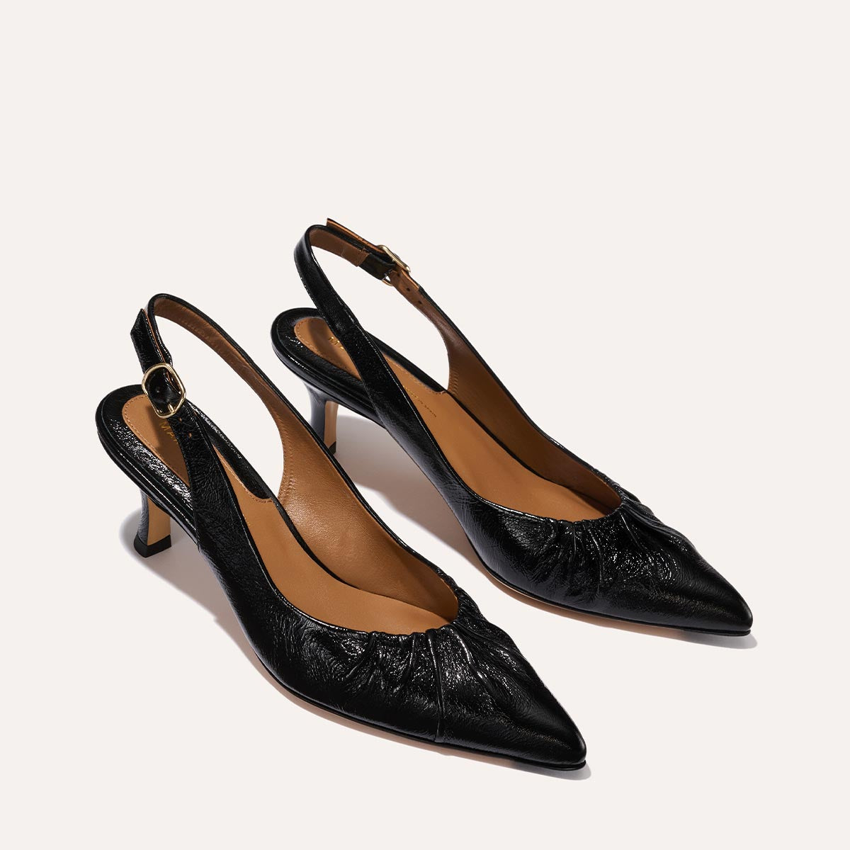 The Anya Slingback in shiny Black Crinkle-Gloss Nappa, featuring a ruched tapered toe with an adjustable buckle and a comfortable 2.5-inch black heel.