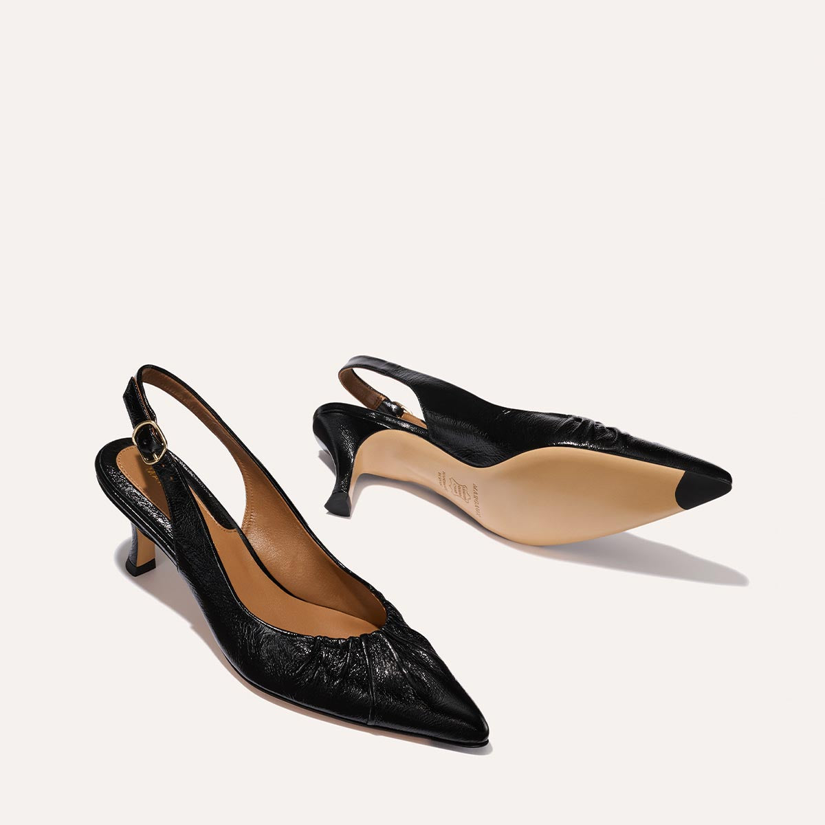 The Anya Slingback in shiny Black Crinkle-Gloss Nappa, featuring a ruched tapered toe with an adjustable buckle and a comfortable 2.5-inch black heel.