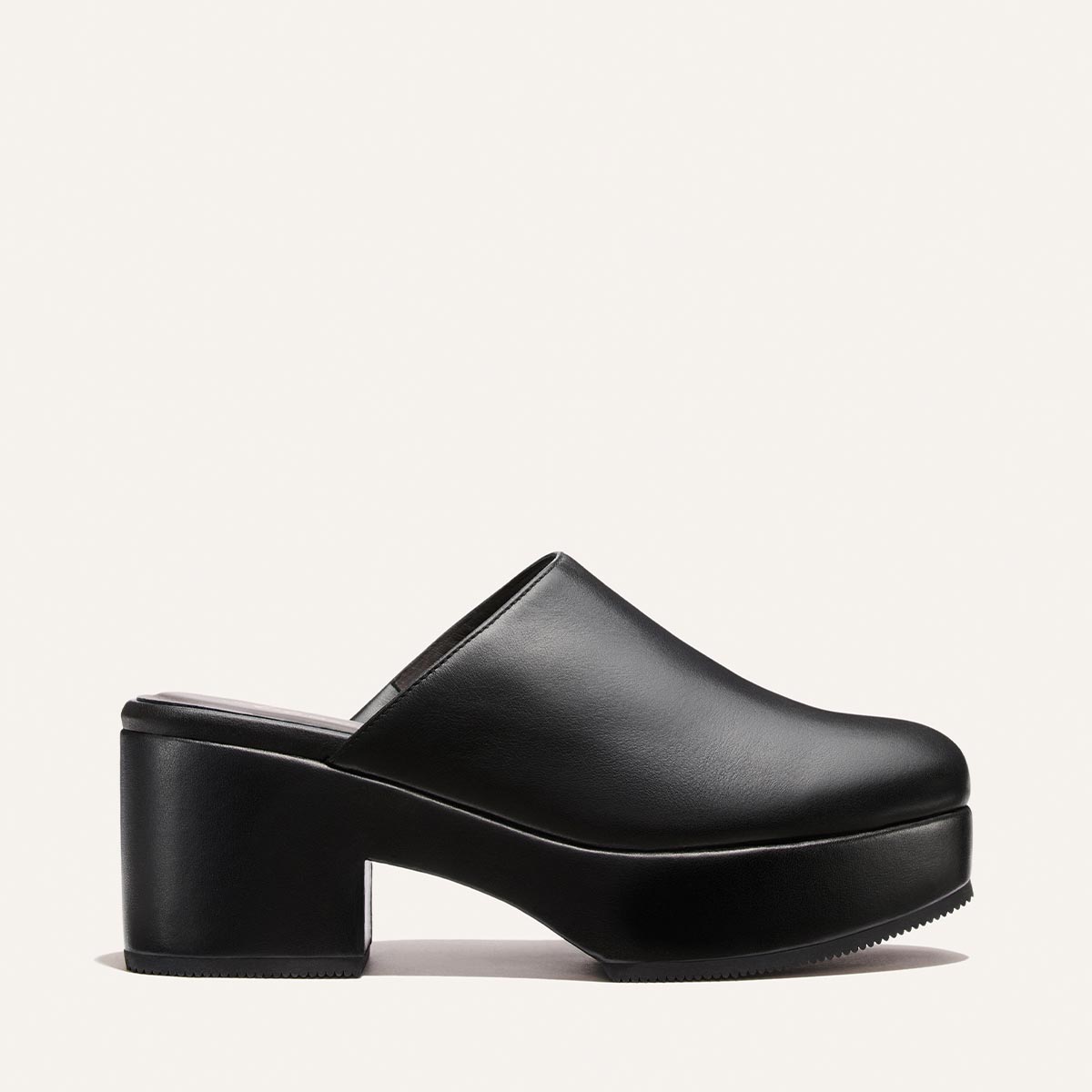The Alison Roman x Margaux: The Atlantic Clog in Black Calf by Margaux, a black slip-on style with a chunky high heel and platform sole, is shown in side profile against a plain, light background.
