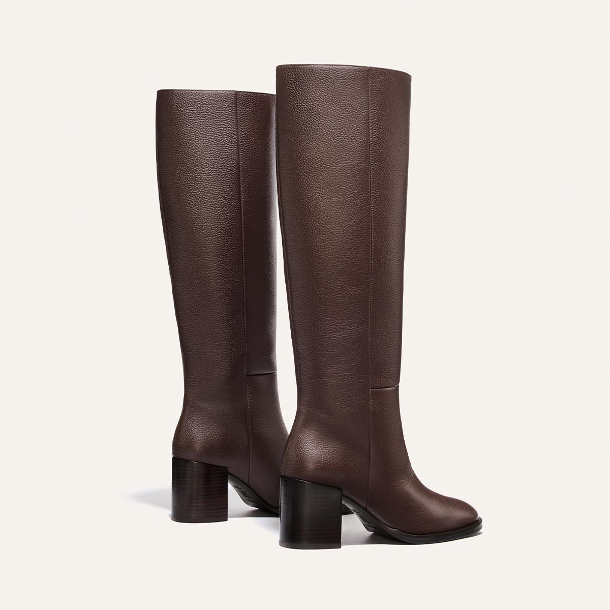 A pair of Margaux Alison Roman x Margaux: The Charlie Boot in brown tumbled calf leather—crafted with a subtle texture and chunky block heels, showcasing the tallest silhouette in refined style—presented side by side against a simple light backdrop.