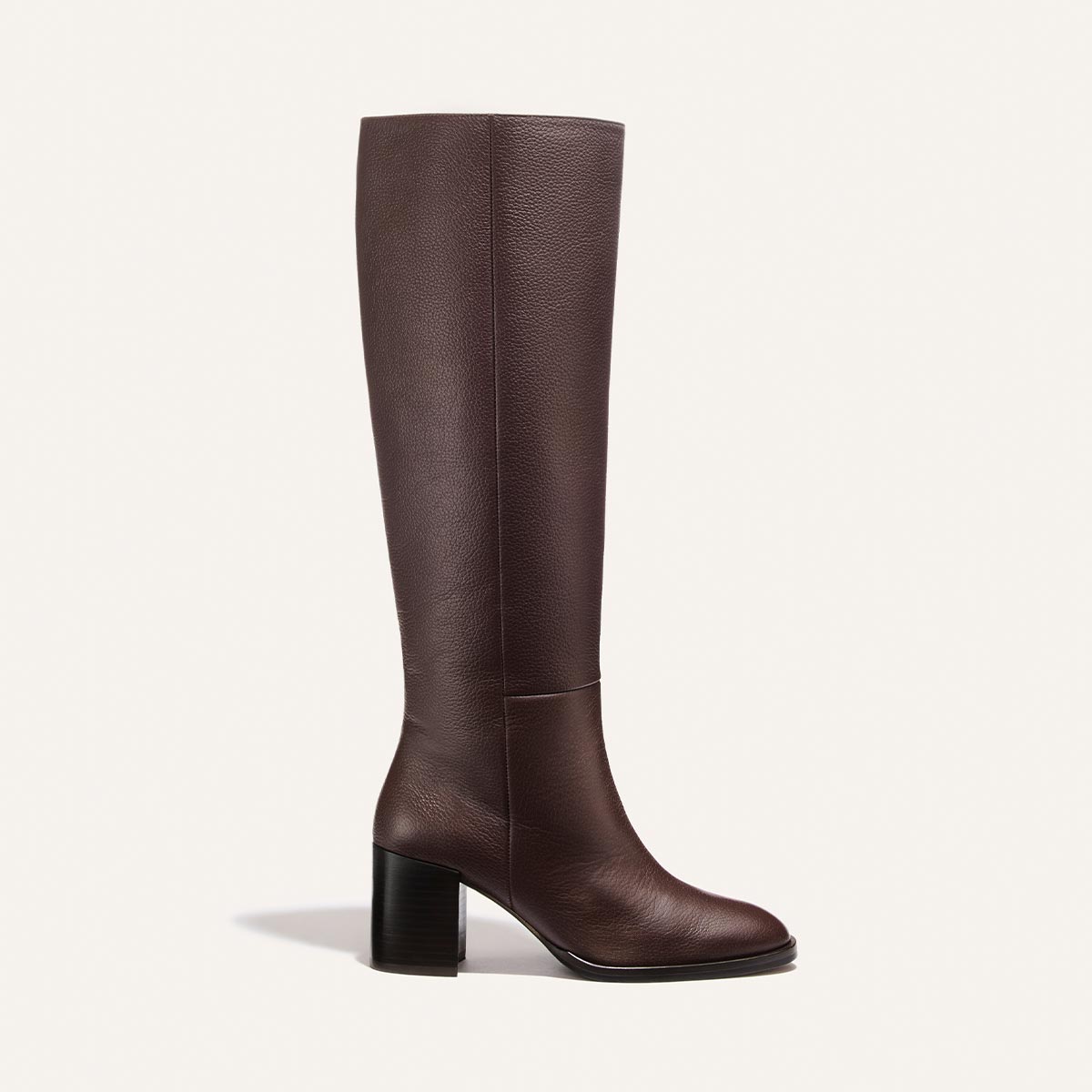 Introducing the Alison Roman x Margaux: The Charlie Boot - Brown Tumbled Calf by Margaux—a single knee-high boot in brown tumbled calf leather, featuring a rounded toe and sturdy block heel, showcased against a plain white background. This is the tallest boot in the collection.