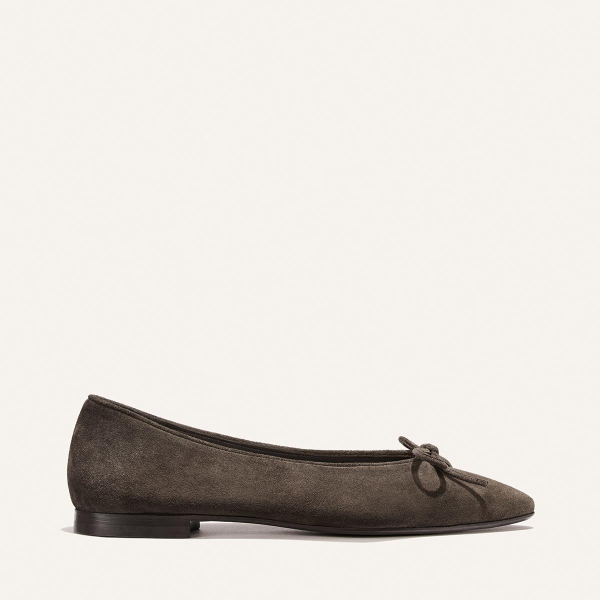 A single Alison Roman x Margaux: The Salamanca - English Brown Suede ballet flat with a bow, shown in profile on a plain white background.