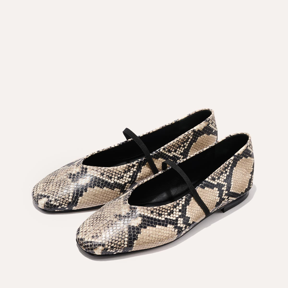 The Phoebe - Natural Python Embossed by margaux-development: soft, flat Mary Jane shoes featuring a beige and black snakeskin pattern with black straps and sacchetto construction, shown on a plain light background.