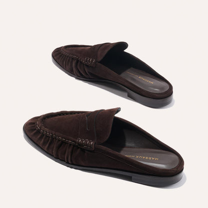 The Astor Loafer Mule in Espresso Suede by margaux-development features a ruched side design and branded insole, shown against a light background.