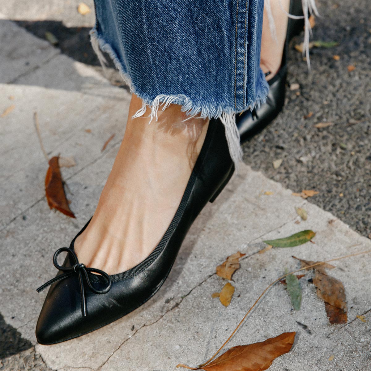 The Pointe in Black Nappa, a classic and comfortable ballet flat featuring a refined pointed toe design and decorative bow. 