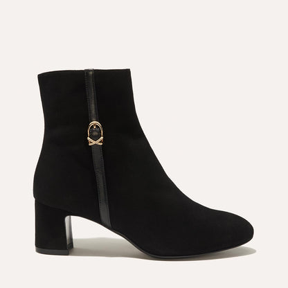 The Bowery Boot in Black Suede, crafted from luxurious Italian suede featuring a sleek almond toe, elegant breasted heel, and a gold-tone buckle detail. 