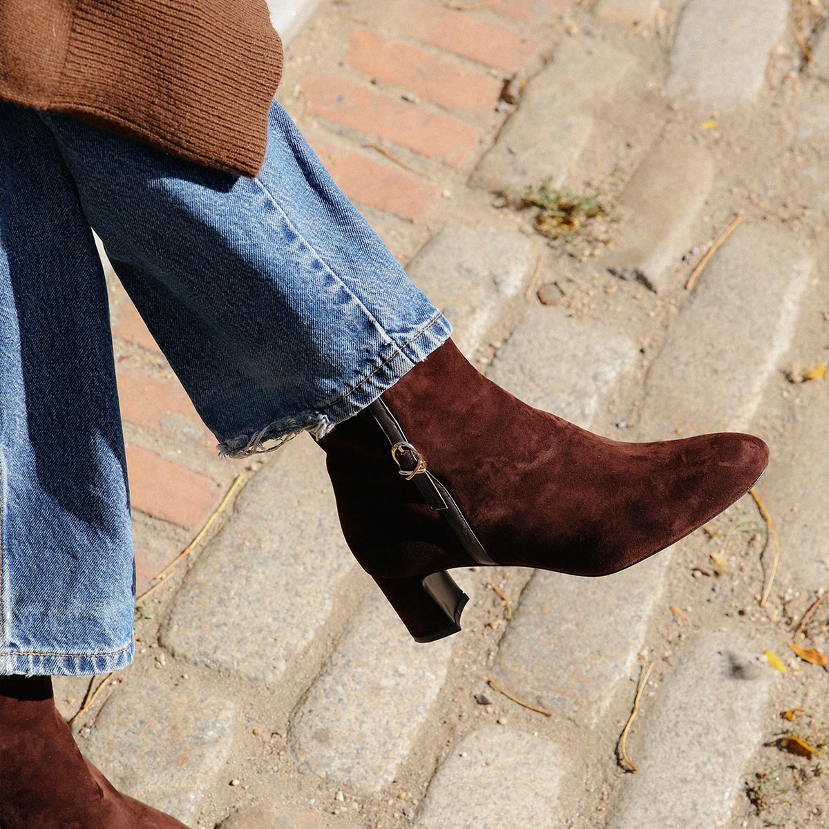 The Bowery Boot in Chocolate Suede, crafted from luxurious Italian suede featuring a sleek almond toe, elegant breasted heel, and a gold-tone buckle detail. 