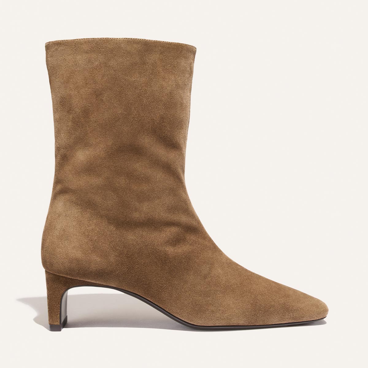 The Brera Boot - Driftwood Suede by Margaux is a tan suede, mid-calf boot featuring a low, angled heel and a pointed toe, displayed in side profile against a plain light background.