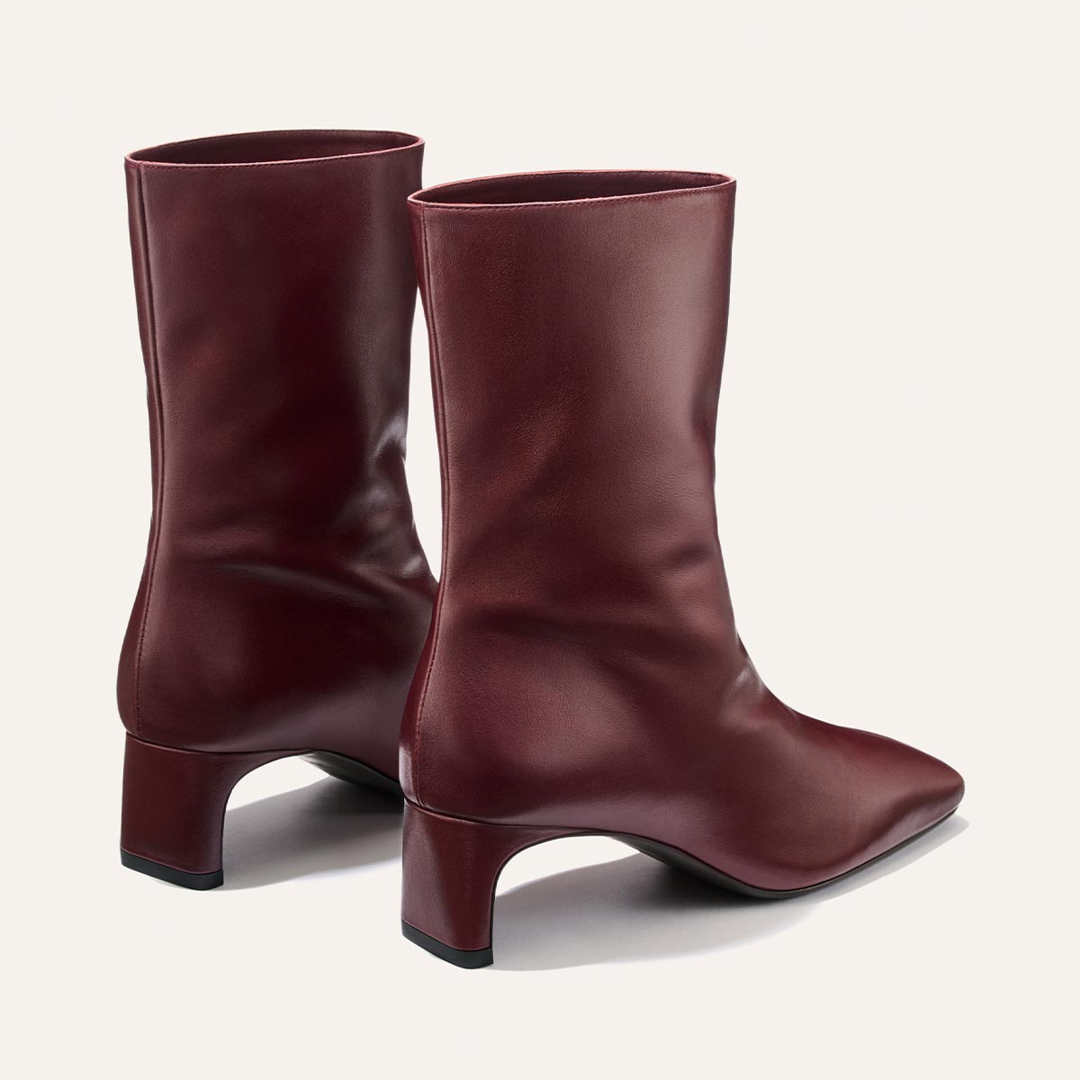 A pair of burgundy leather The Brera Boot - Merlot Calf mid-calf boots with square toes, padded insoles, and 2″ block heels.
