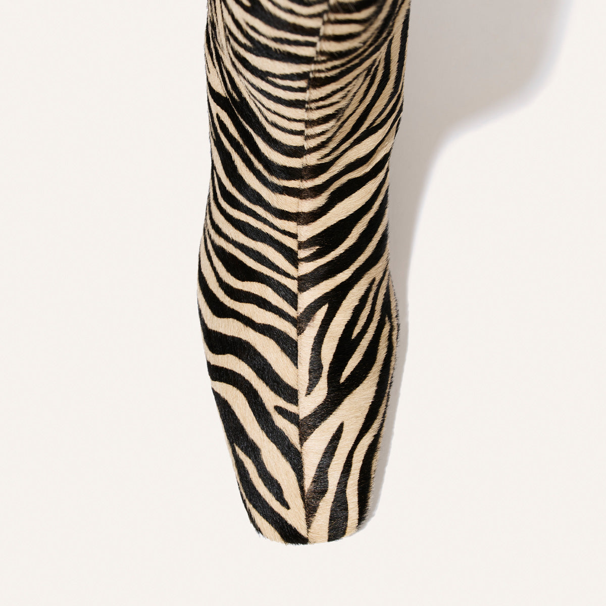 Close-up of The Brera Boot - Tan Zebra Haircalf featuring a square-toe, black and tan zebra stripe pattern, and a 2″ heel.