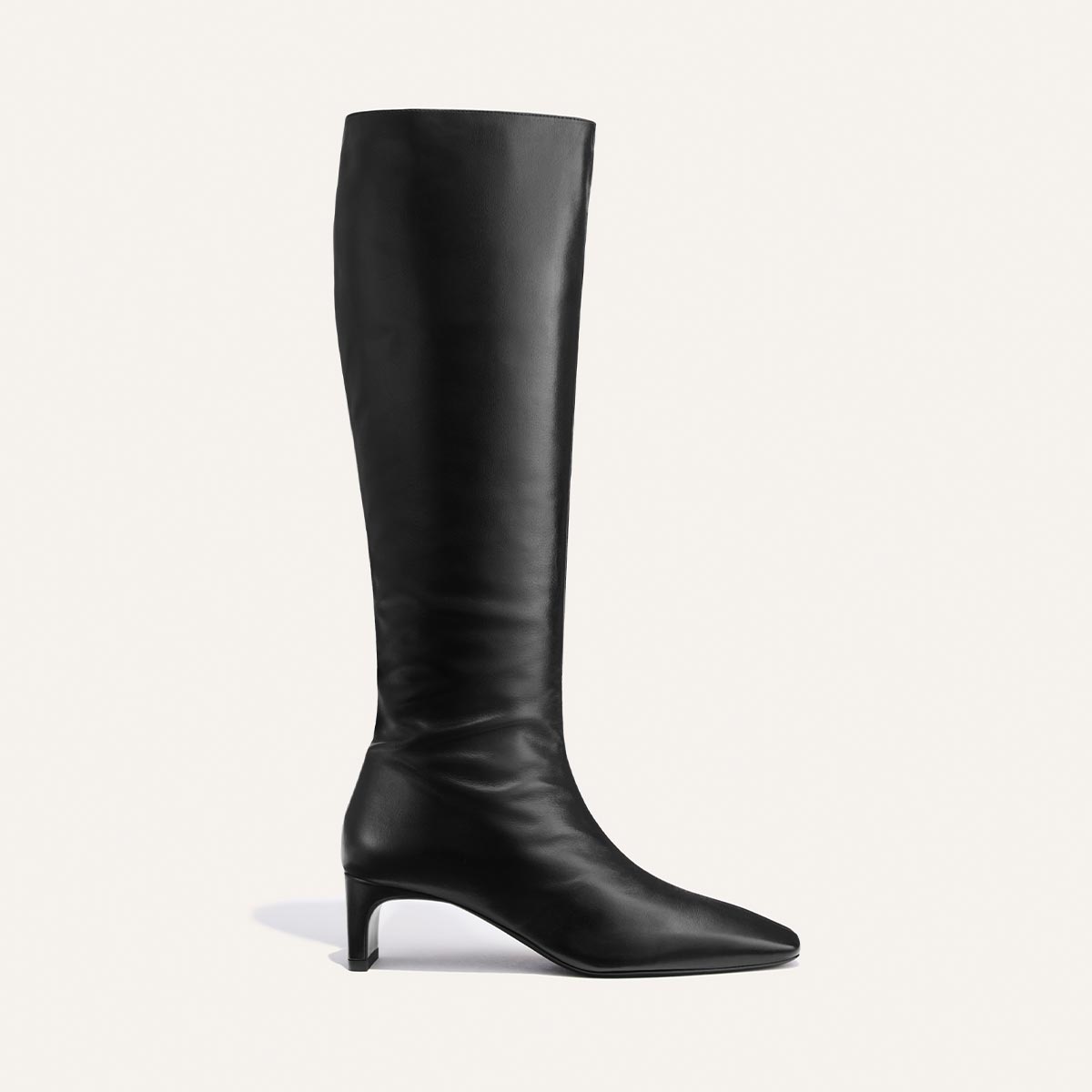 Introducing The Brera Knee-High Boot in Black Calf by Margaux: a single black knee-high leather boot featuring a low heel, pointed toe, and smooth finish, displayed in side profile against a plain white background.