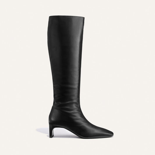 Introducing The Brera Knee-High Boot in Black Calf by Margaux: a single black knee-high leather boot featuring a low heel, pointed toe, and smooth finish, displayed in side profile against a plain white background.