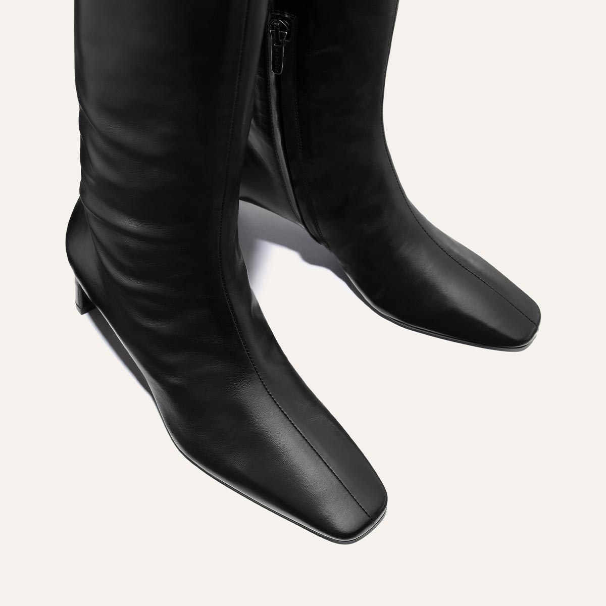 The Brera Knee-High Boot by Margaux in black calf leather, featuring a square toe and low heel, is shown from above against a plain white background.