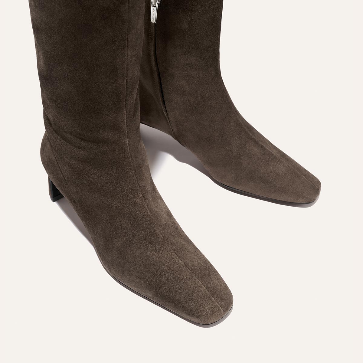 Close-up of The Brera Knee-High Boot in English Brown Suede by Margaux, featuring square toes, low block heels, a walkable heel, and a padded insole for added comfort, shown on a light background.