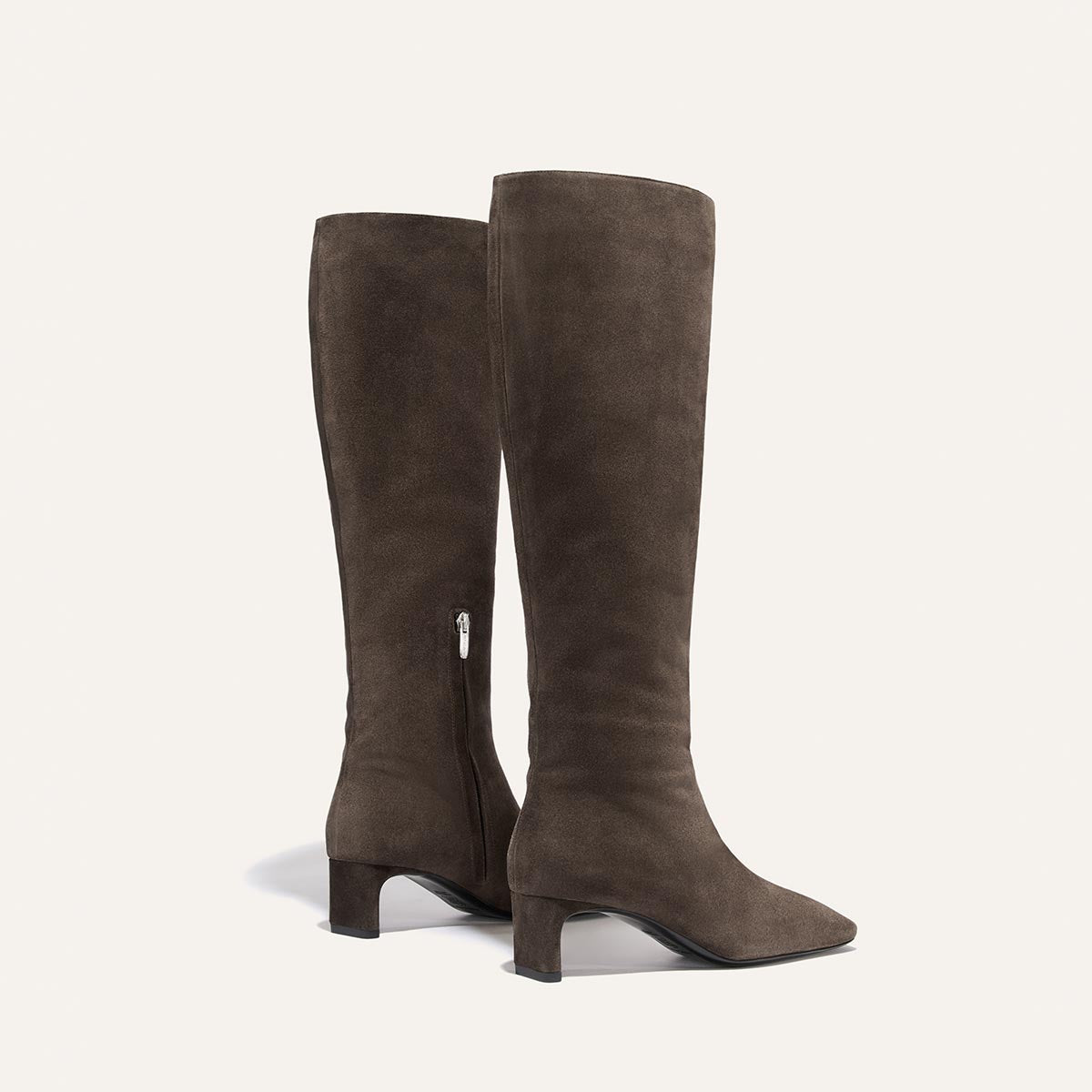 The Brera Knee-High Boot in English Brown Suede featuring a side zipper, a walkable low block heel, and a padded insole.
