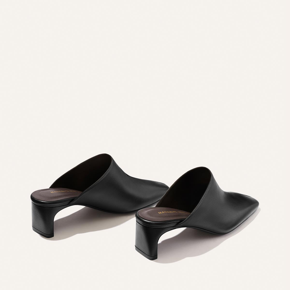 The Brera Mule - Black Nappa by Margaux features black leather with open backs, square toes, and low block heels, displayed at an angle on a plain white background.