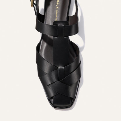 Black sandal with woven design on a white background