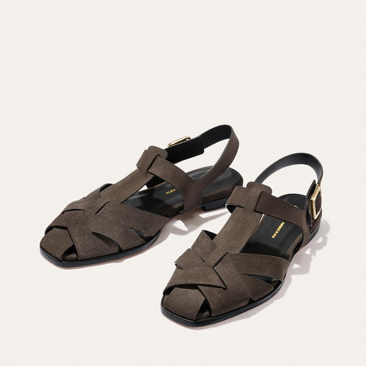 Margaux The Calypso Fisherman - English Brown Suede sandals featuring a dark brown suede finish, square toes, a modern interwoven pattern, and gold-tone side buckles.