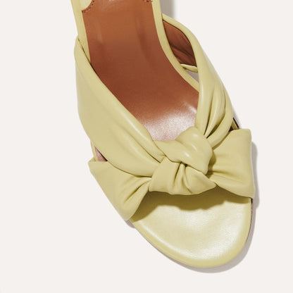 The Carmine Mule in Pear Nappa, a slide-on heel featuring a plush knot detail and comfortable 2.5-inch block heel