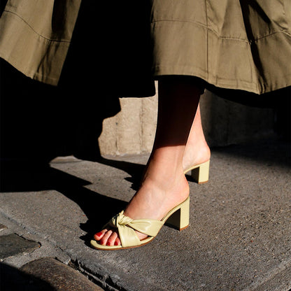 The Carmine Mule in Pear Nappa, a slide-on heel featuring a plush knot detail and comfortable 2.5-inch block heel