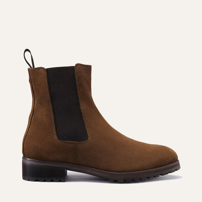 Margaux's The Chelsea Boot - Moss Suede features earthy suede, a black elastic side panel, back pull tab, and a durable dark rubber sole, all displayed against a neutral background.