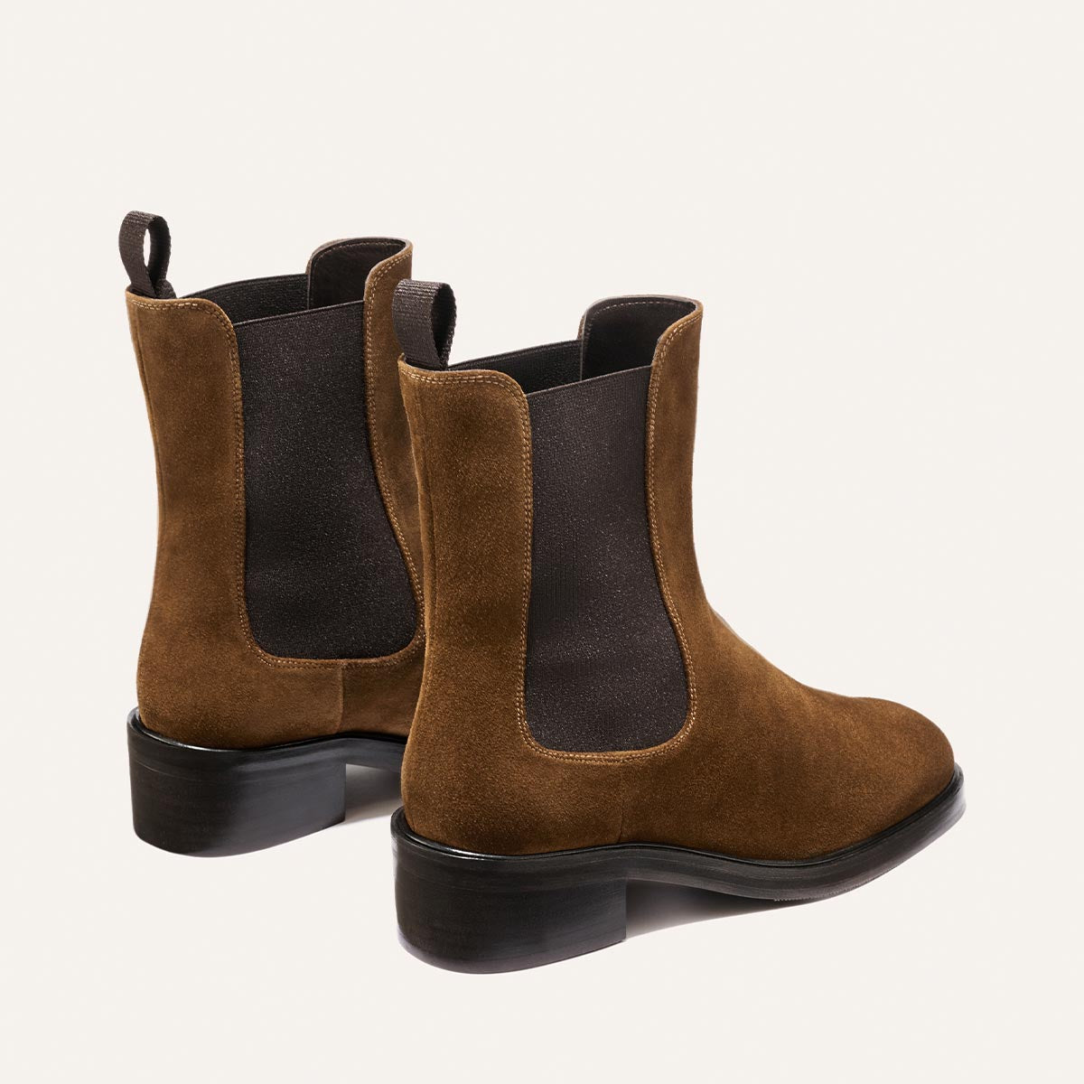 The City Chelsea Boot - Cedar Suede by Margaux is a pair of brown suede boots featuring black elastic side panels, pull tabs at the back, and low black heels, displayed against a plain light background.
