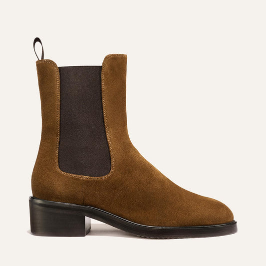 The City Chelsea Boot - Cedar Suede by Margaux features brown suede, a black elastic side panel, black pull tab, and a low black heel, shown against a light background.