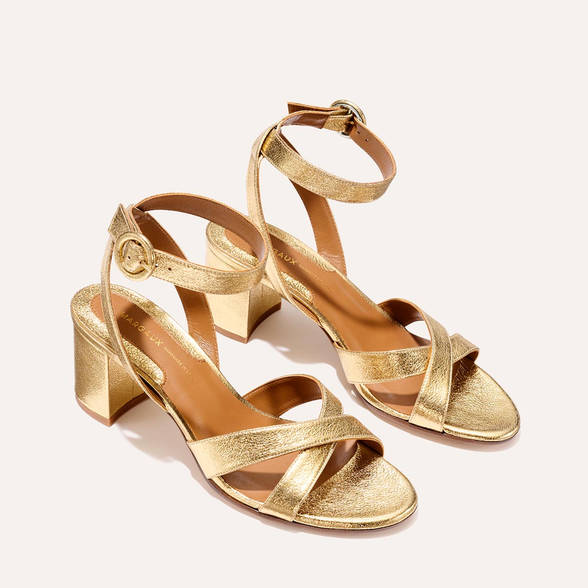 The City Sandal in shiny Gold Crinkle Nappa, featuring carefully placed straps, an adjustable ankle strap and a comfortable 2.5-inch block heel.