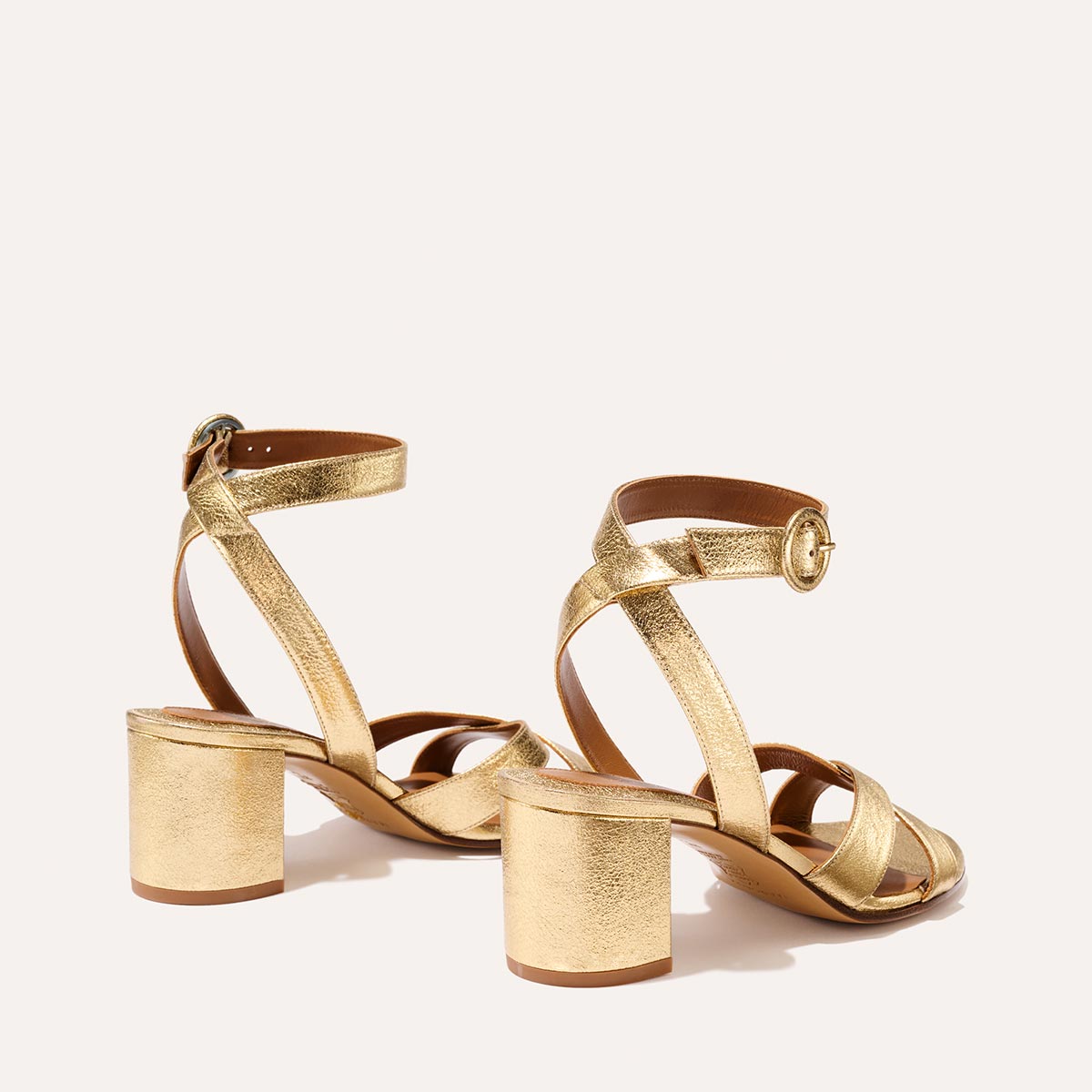 The City Sandal in shiny Gold Crinkle Nappa, featuring carefully placed straps, an adjustable ankle strap and a comfortable 2.5-inch block heel.