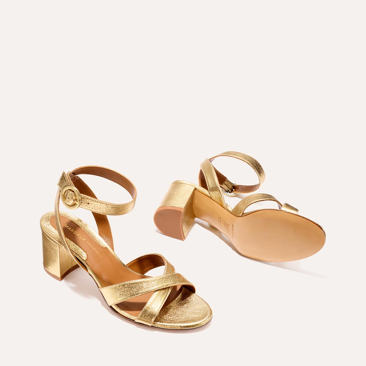 The City Sandal in shiny Gold Crinkle Nappa, featuring carefully placed straps, an adjustable ankle strap and a comfortable 2.5-inch block heel.