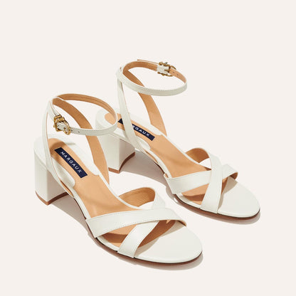 The City Sandal in Ivory Nappa, featuring carefully placed straps, and adjustable ankle strap and a comfortable 2.5-inch block heel.