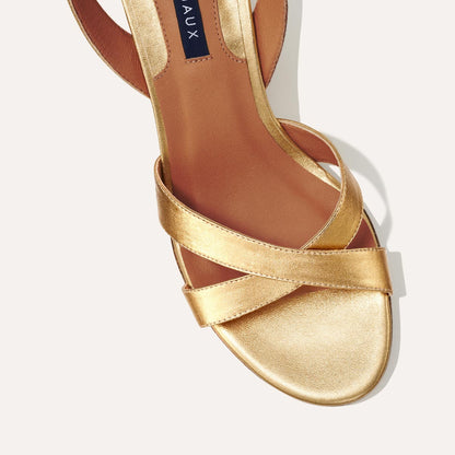 The City Sandal in metallic Gold Nappa, featuring carefully placed straps, and adjustable ankle strap and a comfortable 2.5-inch block heel.