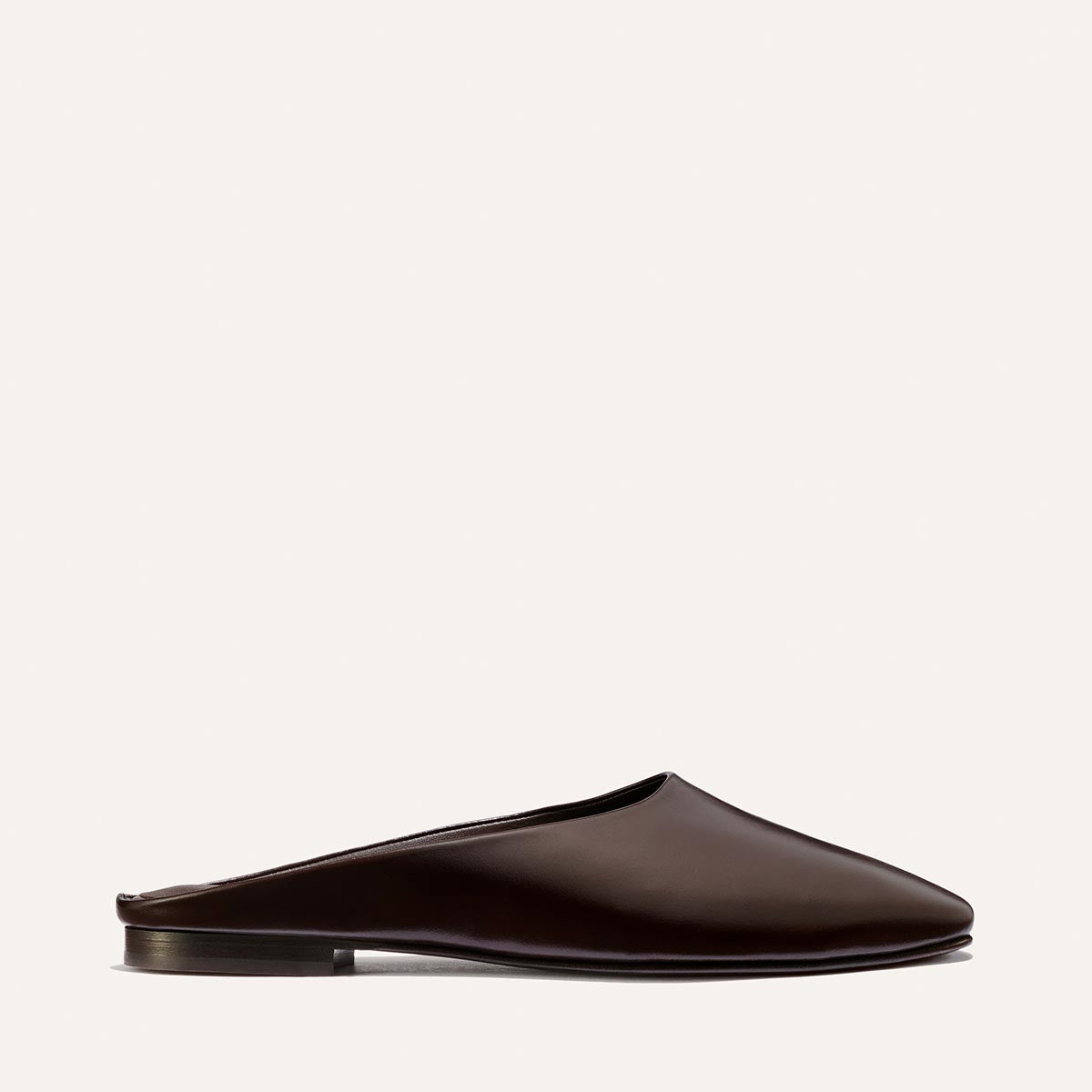 The Clara - Coffee Calf by Margaux: a dark brown leather slip-on mule featuring a slipper-like silhouette and flat sole, displayed in side profile against a plain light background.