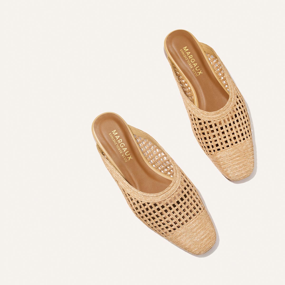 Pair of beige woven shoes on a light beige background