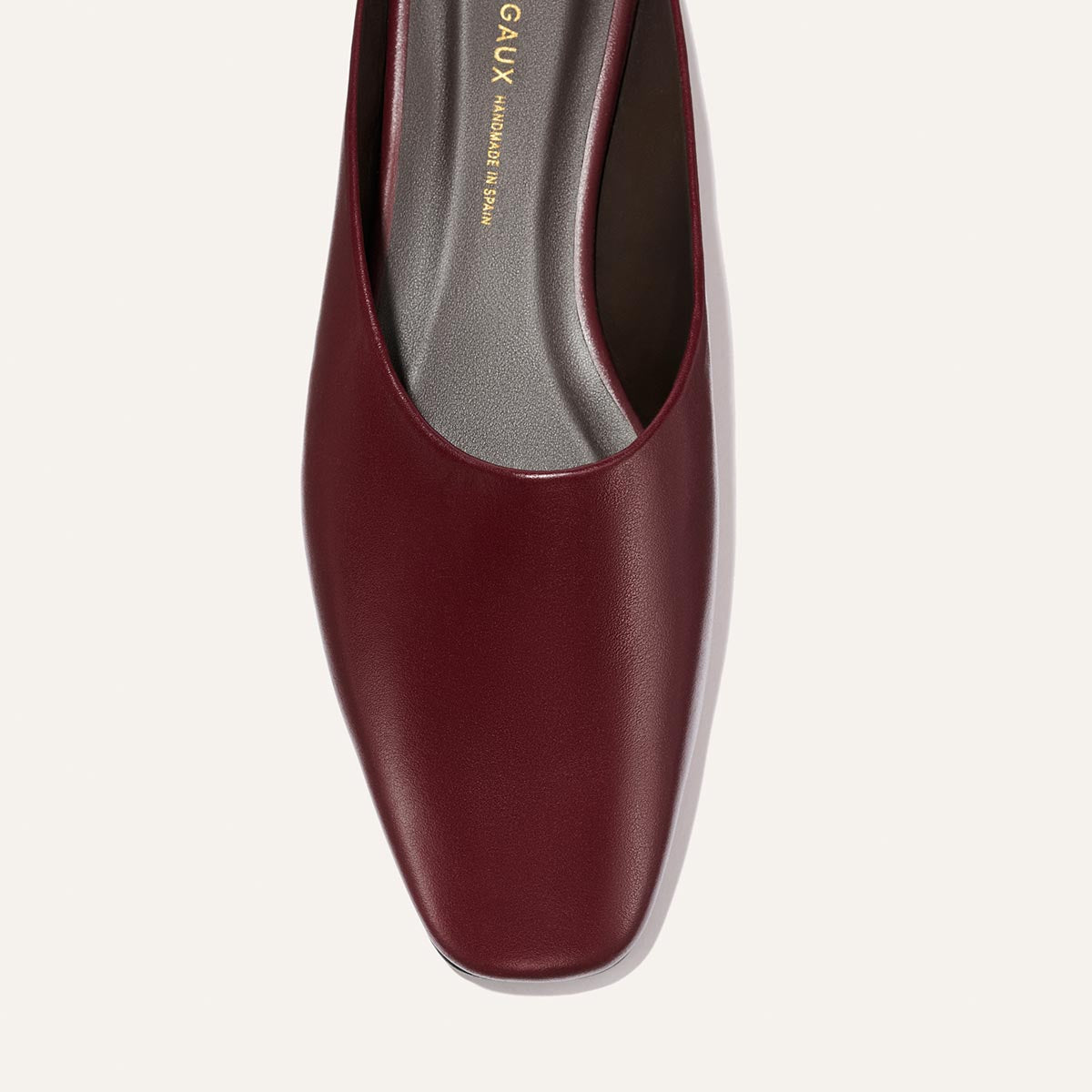 Close-up top view of The Clara - Wine Calf, a do-it-all style flat by Margaux, featuring burgundy leather, a square toe, and a gray insole with gold branding on the inner sole. Set against a plain light-colored background.