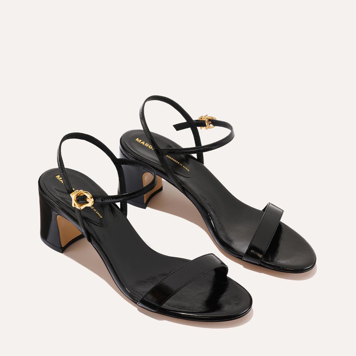 The Cleo Sandal in Black Crinkle-Gloss Nappa, a comfortable 2.5-inch heeled sandal with a sleek strap across the toes and perfectly placed instep strap.