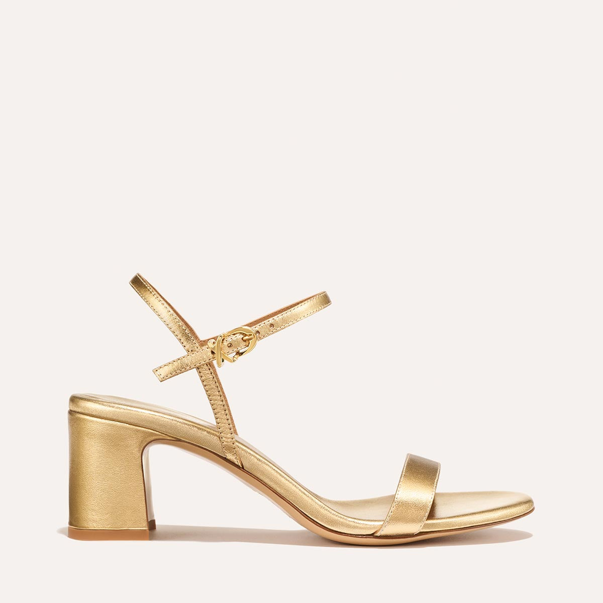 The Cleo Sandal in shiny Gold Nappa, a comfortable 2.5-inch heeled sandal with a sleek strap across the toes and perfectly placed instep strap.