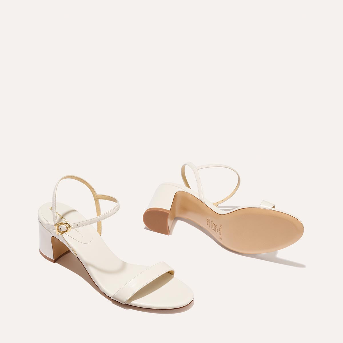 The Cleo Sandal in Ivory Nappa, a comfortable 2.5-inch heeled sandal with a sleek strap across the toes and perfectly placed instep strap.