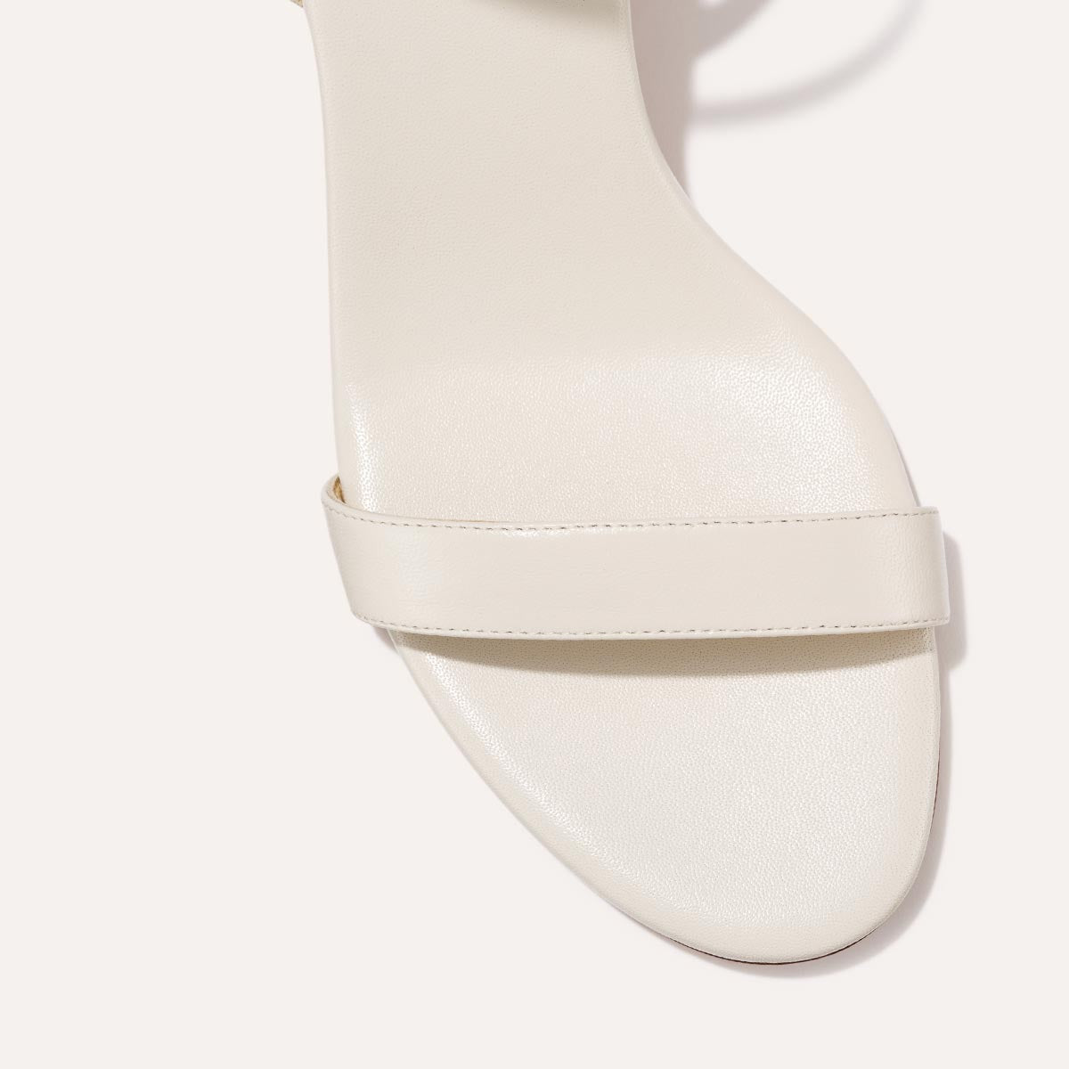 The Cleo Sandal in Ivory Nappa, a comfortable 2.5-inch heeled sandal with a sleek strap across the toes and perfectly placed instep strap.