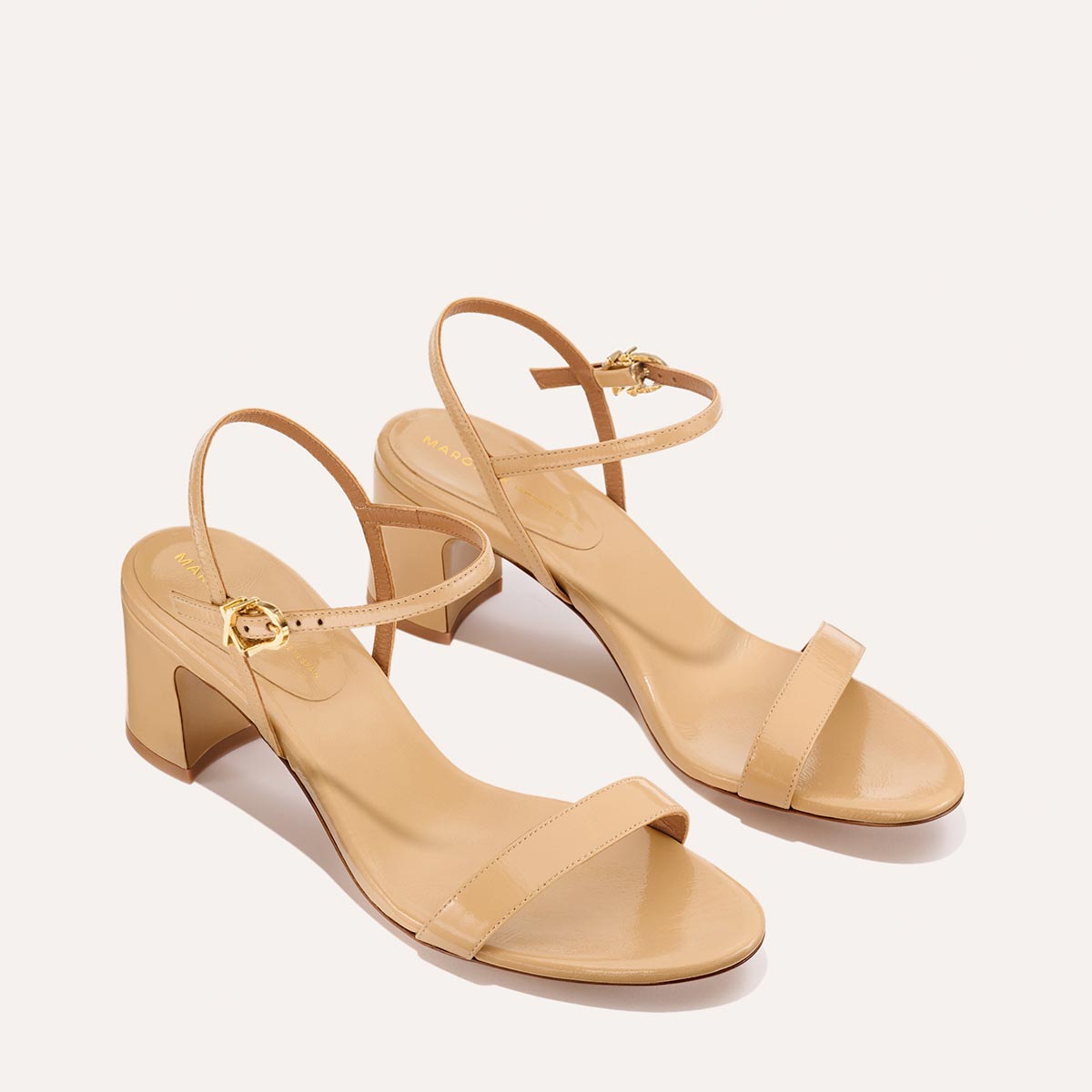 The Cleo Sandal in Sand Crinkle-Gloss Nappa, a comfortable 2.5-inch heeled sandal with a sleek strap across the toes and perfectly placed instep strap.