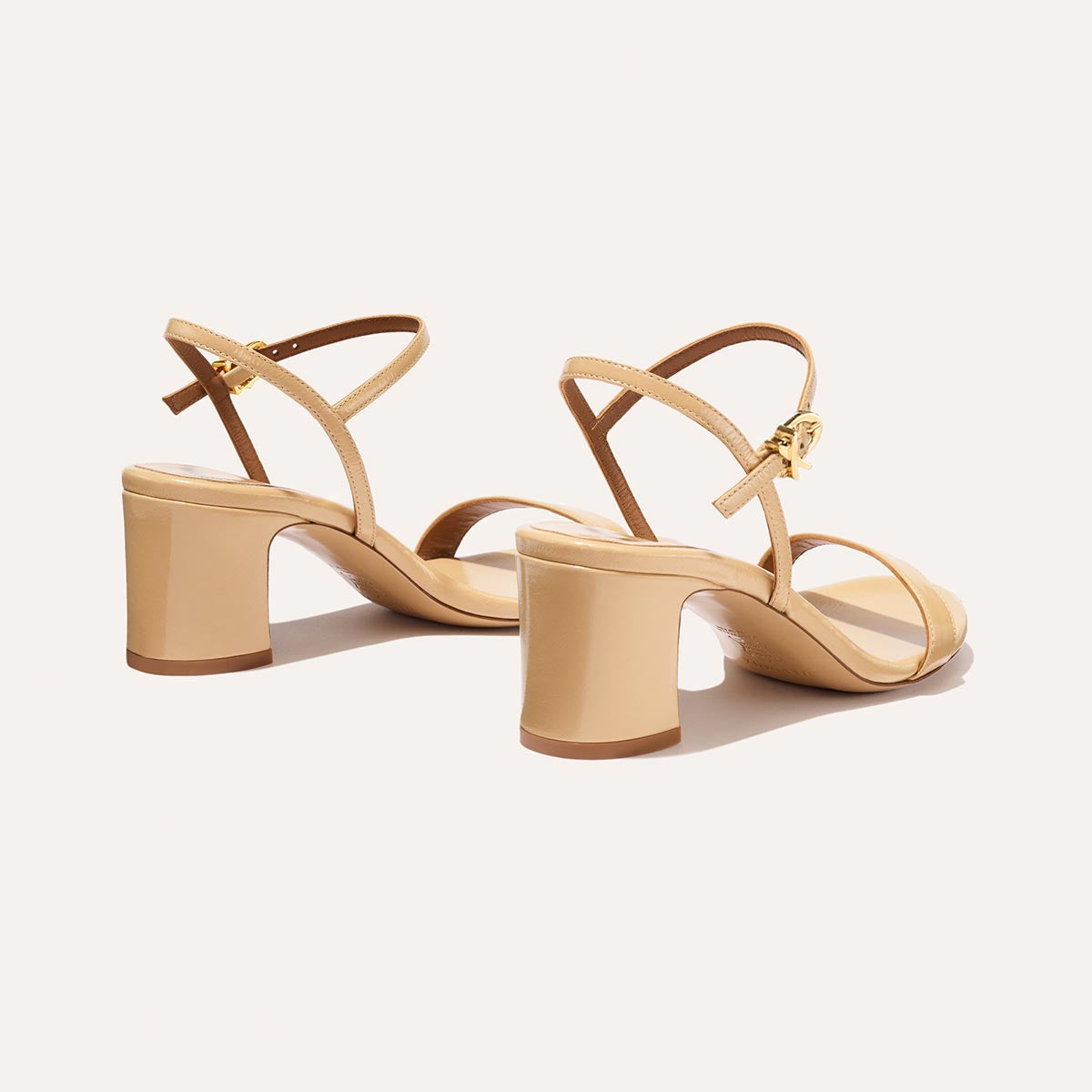 The Cleo Sandal in Sand Crinkle-Gloss Nappa, a comfortable 2.5-inch heeled sandal with a sleek strap across the toes and perfectly placed instep strap.