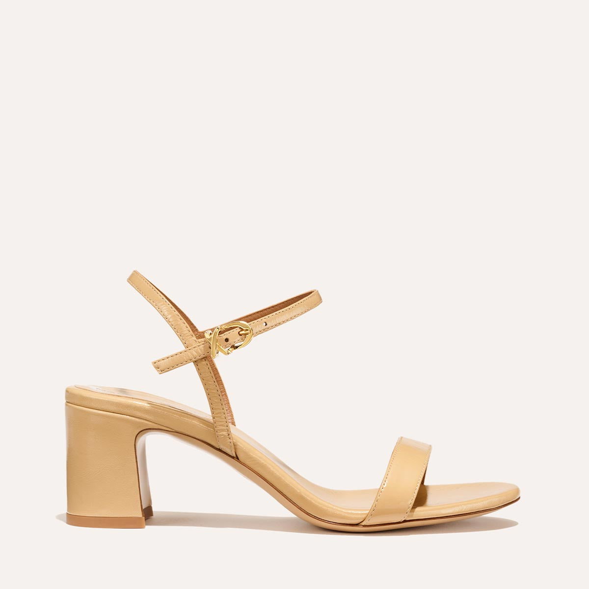 The Cleo Sandal in Sand Crinkle-Gloss Nappa, a comfortable 2.5-inch heeled sandal with a sleek strap across the toes and perfectly placed instep strap.