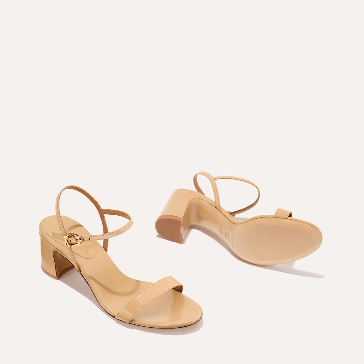 The Cleo Sandal in Sand Crinkle-Gloss Nappa, a comfortable 2.5-inch heeled sandal with a sleek strap across the toes and perfectly placed instep strap.