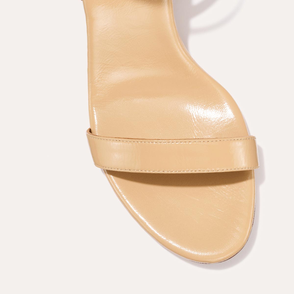 The Cleo Sandal in Sand Crinkle-Gloss Nappa, a comfortable 2.5-inch heeled sandal with a sleek strap across the toes and perfectly placed instep strap.