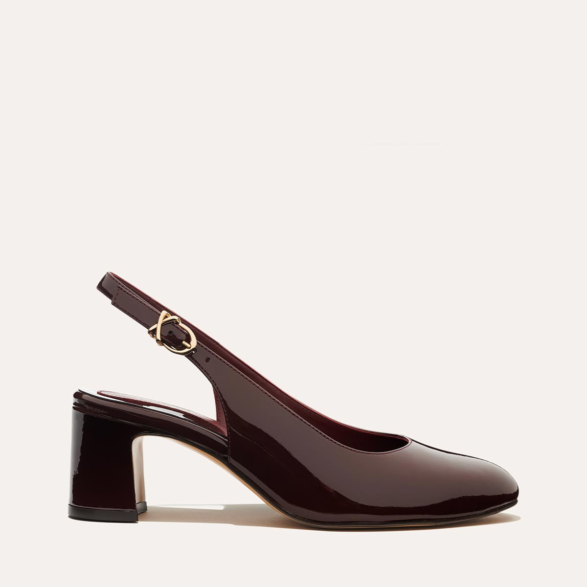 The Cluny Slingback in Burgundy Patent, featuring a sleek Italian nappa leather upper with an adjustable buckle and a comfortable 2.5-inch black heel.