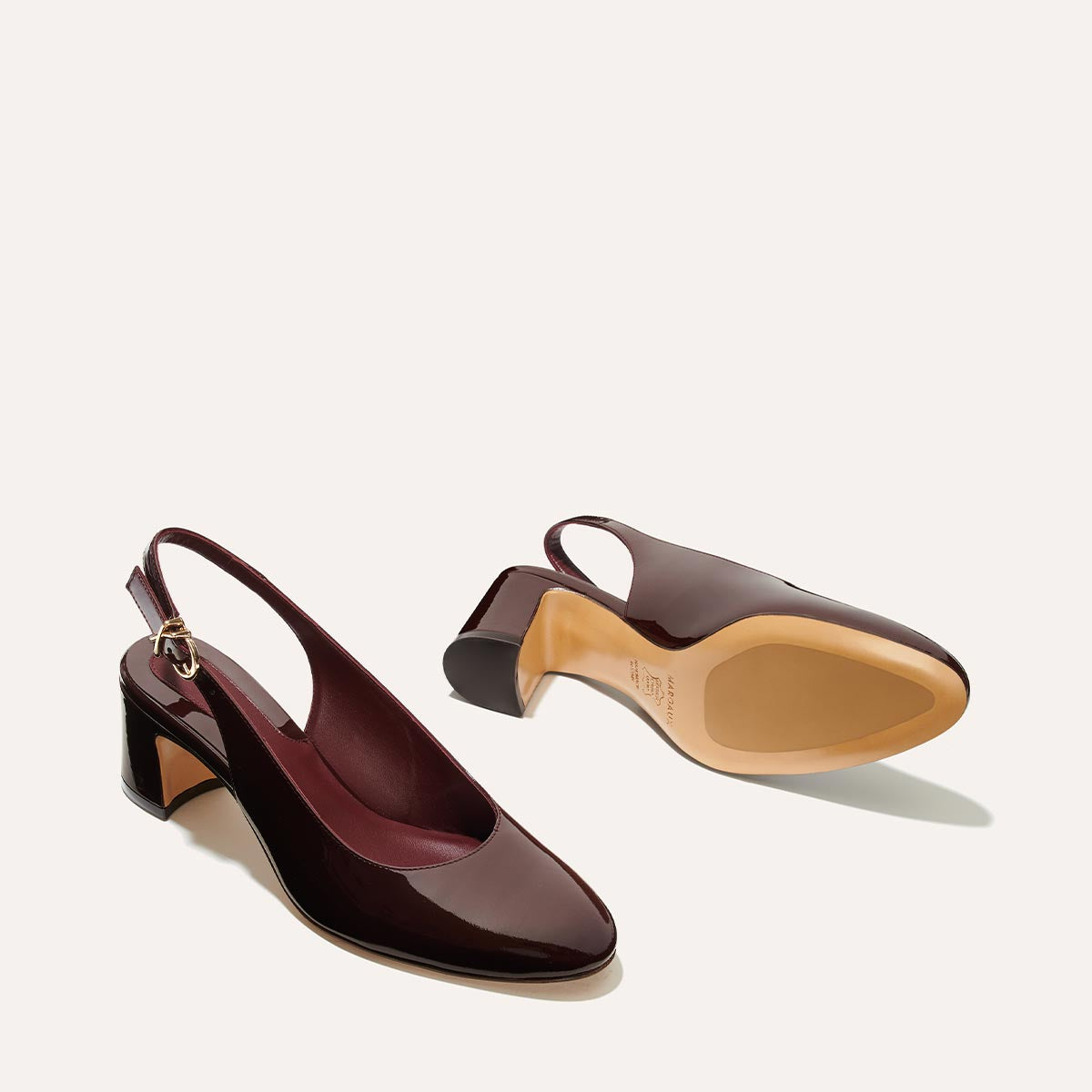 The Cluny Slingback in Burgundy Patent, featuring a sleek Italian nappa leather upper with an adjustable buckle and a comfortable 2.5-inch black heel.