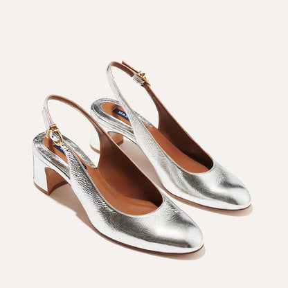 The Cluny Slingback in shiny Silver Crinkle Nappa, featuring a sleek Italian nappa leather upper with an adjustable buckle and a comfortable 2.5-inch black heel.